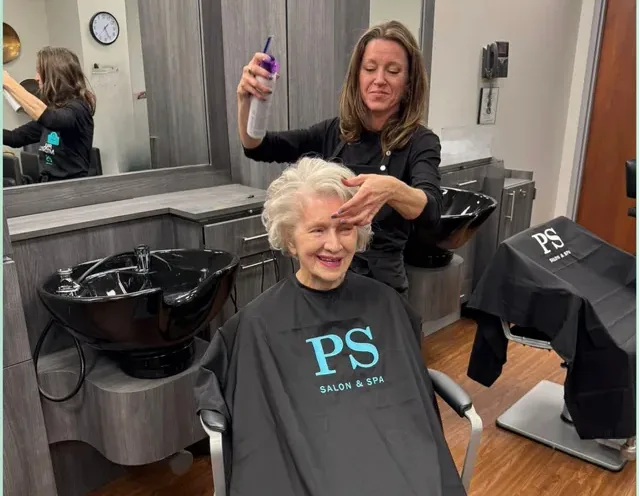 PS Salon & Spa Professional styling a smiling resident