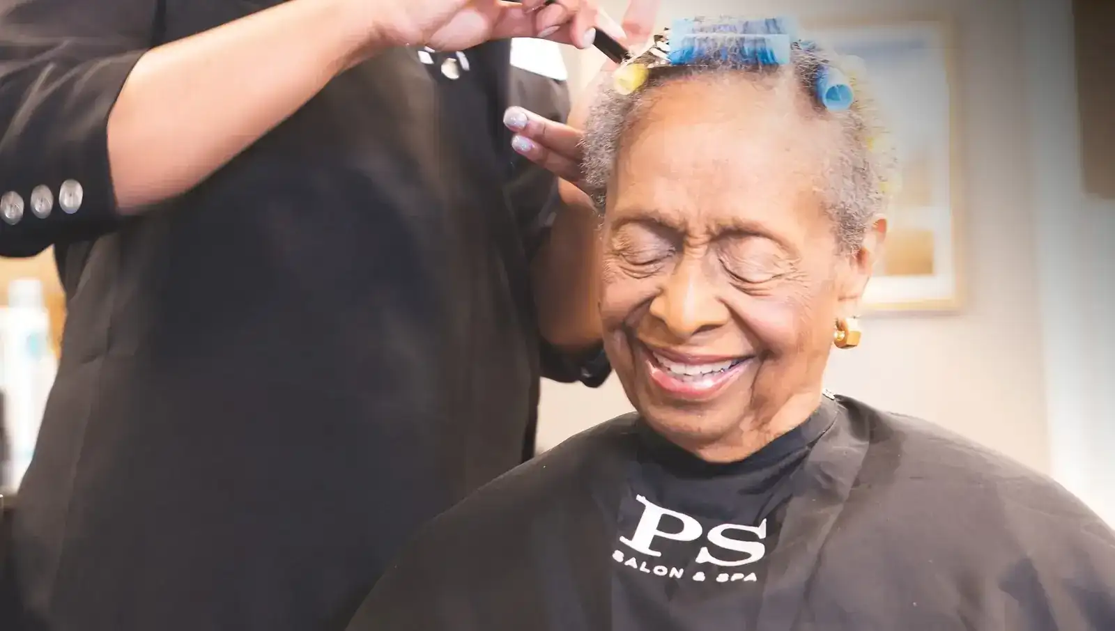 Smiling resident receiving a hair service at PS Salon & Spa